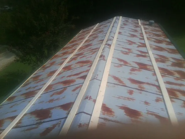 Rusted metal roof panels with new wood purlins before replacement — Storm Damage Roof Repair in Opelousas by Roofing Brothers