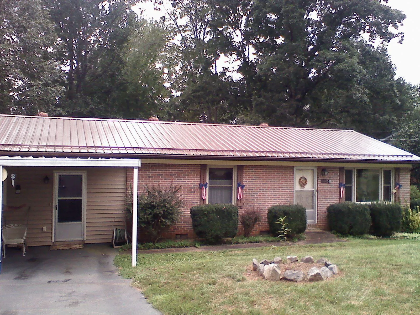 Bronze metal roof and carport on a brick ranch home — Roof Repair work by our crew in Opelousas