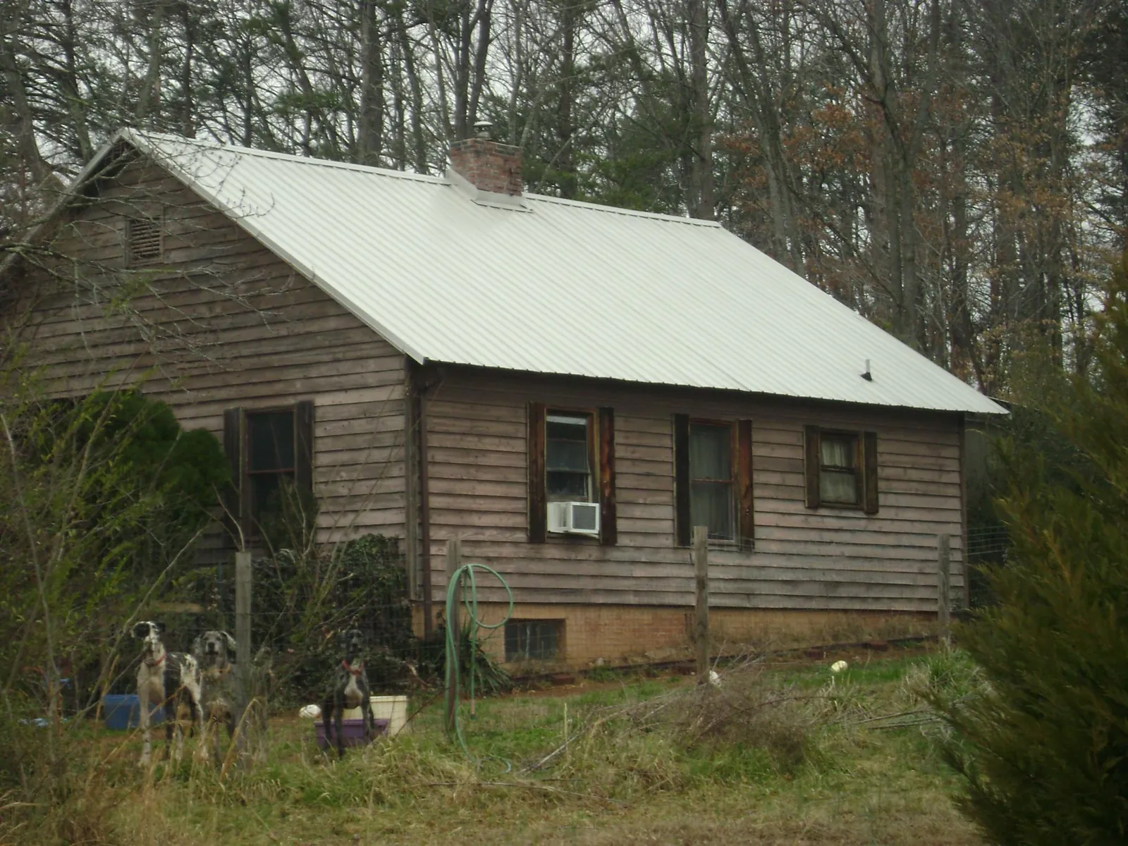 White metal roof on an old wood sided farmhouse, from a Metal Roof Installation job in Opelousas